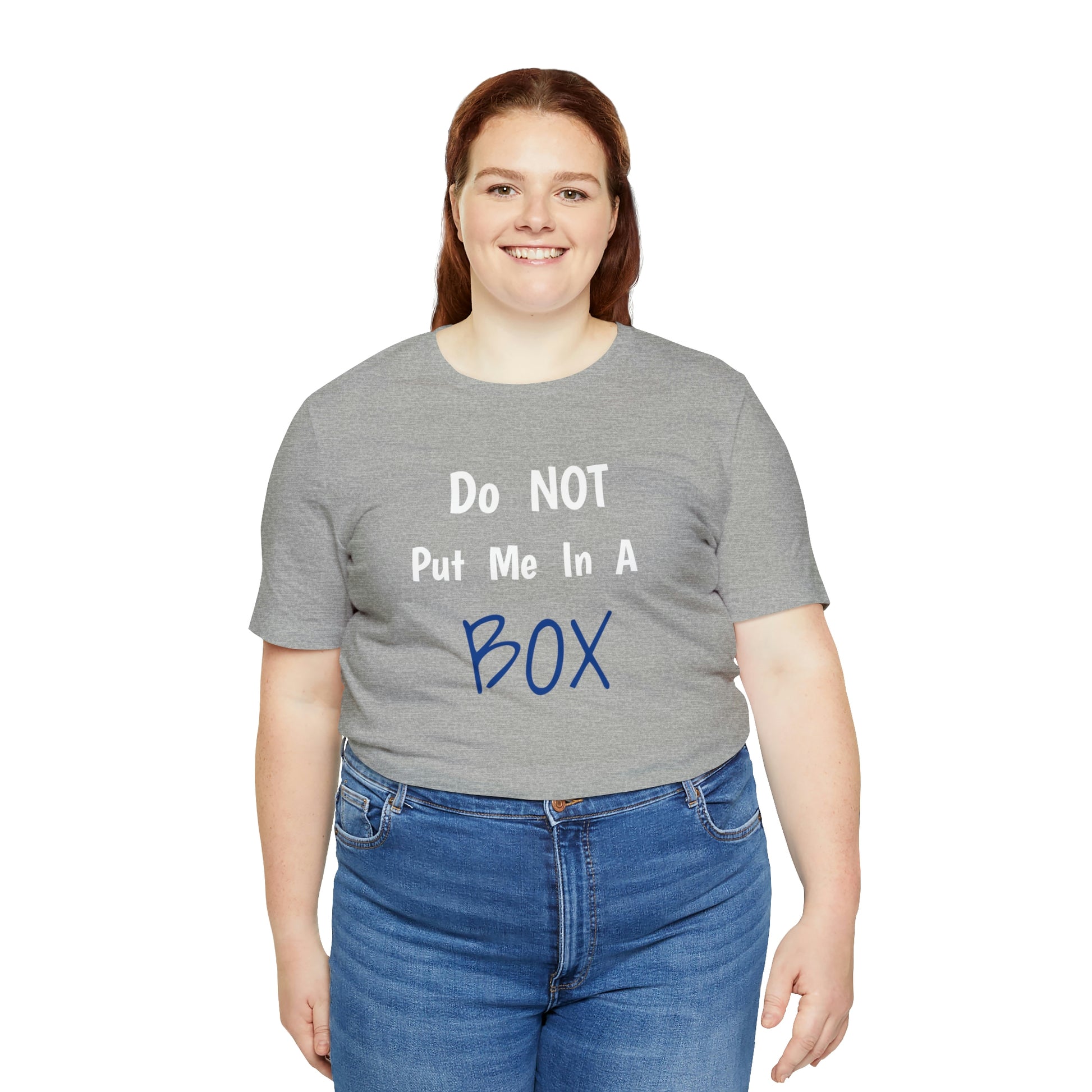 A woman wearing a grey DO NOT PUT ME IN A BOX t-shirt made of airlume combed cotton with a tear away label.